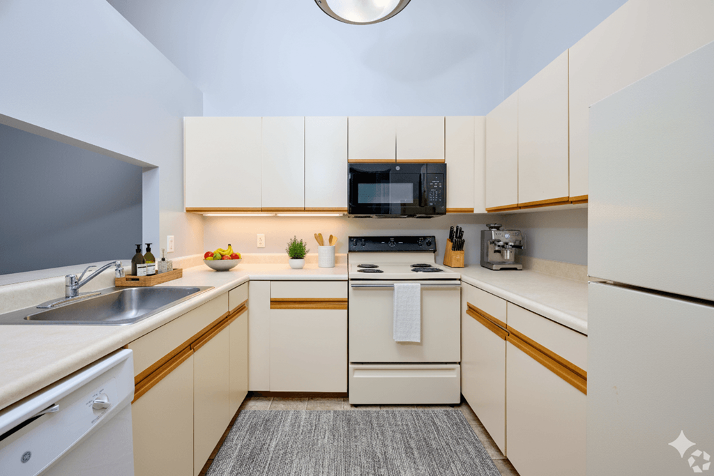 A small, modern kitchen with white appliances and cabinets.