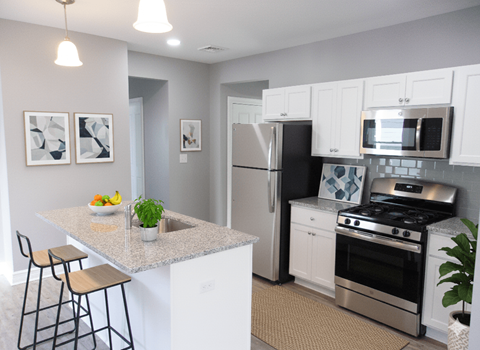 A kitchen with white cabinets and a granite countertop.