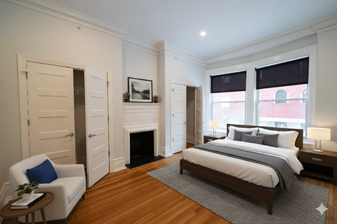 A bedroom with a large bed and a fireplace.