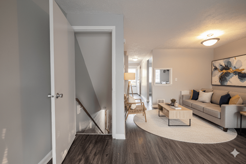 A living room with a couch, coffee table, and a painting on the wall. at Willowbrooke Apartments & Townhomes, New York, 14420