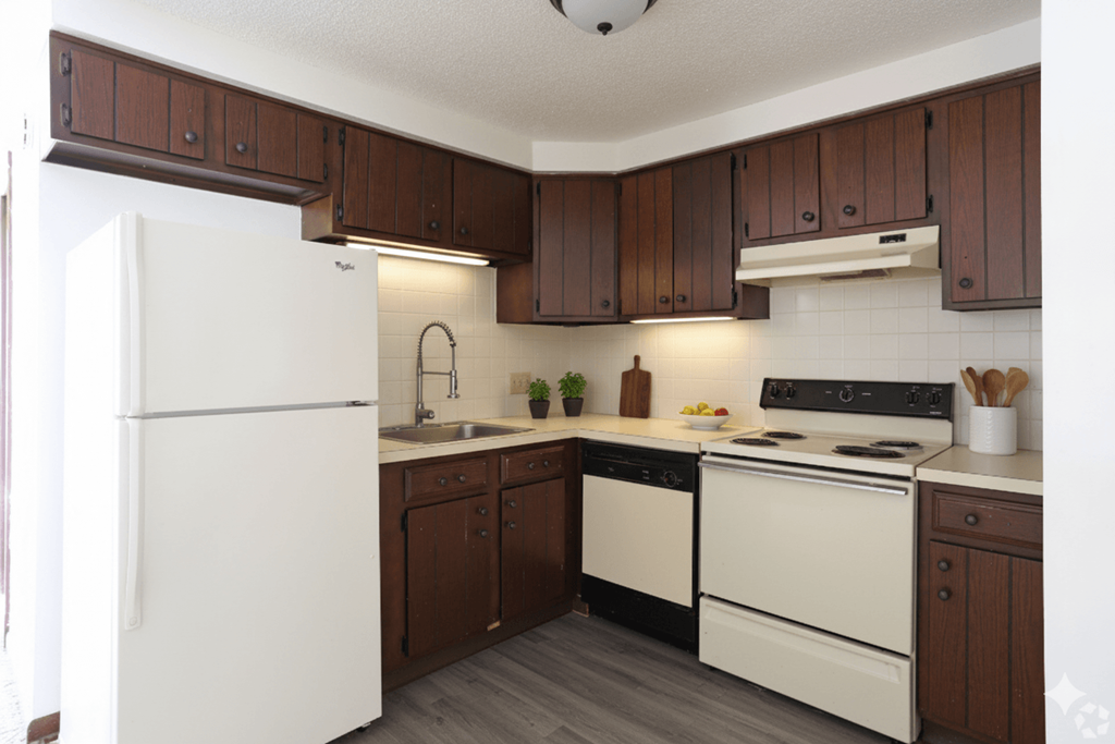 A kitchen with brown cabinets and white appliances.