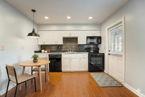 A kitchen with a table and chairs.