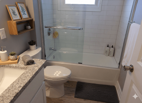 A bathroom with a toilet, sink, and shower.