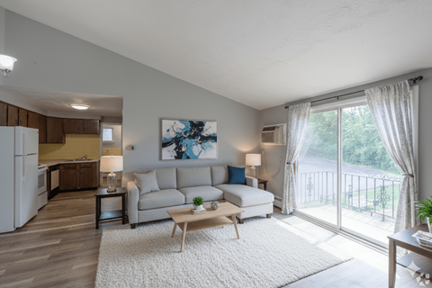 A living room with a couch, a table, and a painting on the wall.
