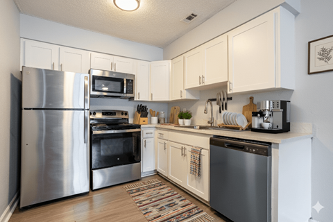 A kitchen with a refrigerator, oven, microwave, and dishwasher.