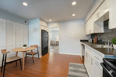 A kitchen with a table and chairs in the foreground.