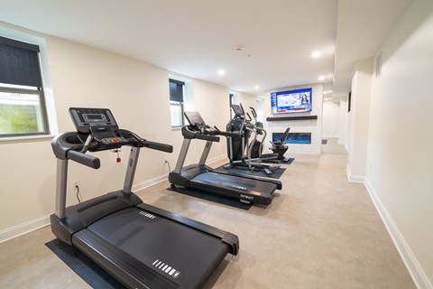A spacious room with treadmills and a television.at The Annex Apartment, Buffalo, 14222