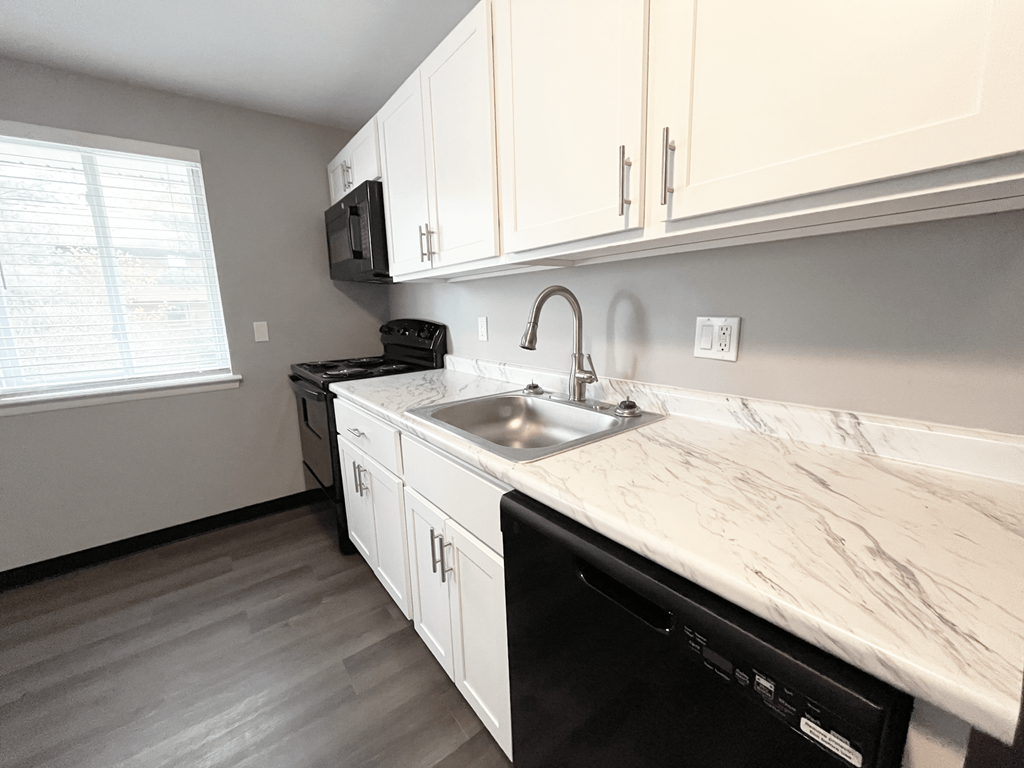 a kitchen with white cabinets and a black stove top oven at Highview Manor Apartments, Fairport, NY, 14450