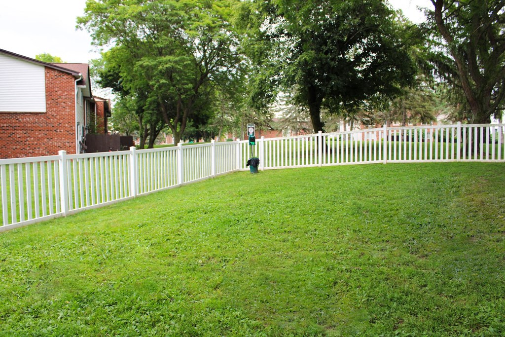 a yard with a white picket fence and a fire hydrant at Highview Manor Apartments, Fairport, New York