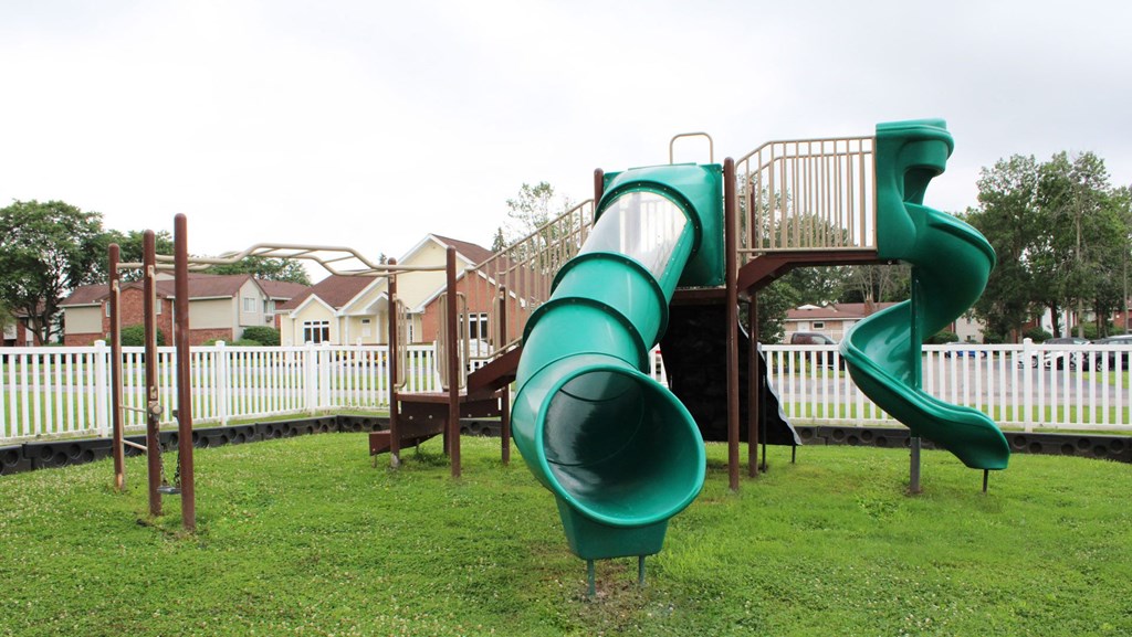 a playground with a large green slide  at Highview Manor Apartments, Fairport, 14450