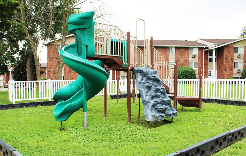a playground with a slide and climbing equipment  at Highview Manor Apartments, Fairport, NY