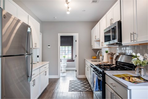 A kitchen with a stainless steel refrigerator and a stainless steel stove.