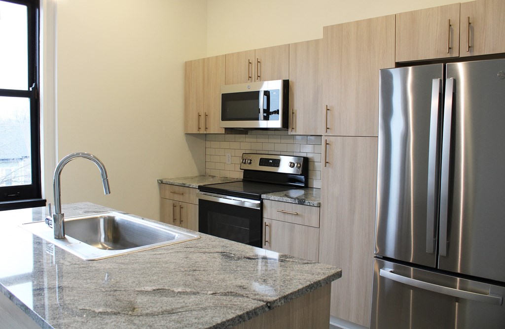 a kitchen with stainless steel appliances and marble counter tops