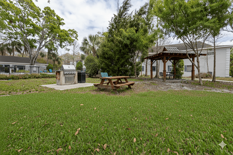 A picnic table sits in the middle of a grassy area.
