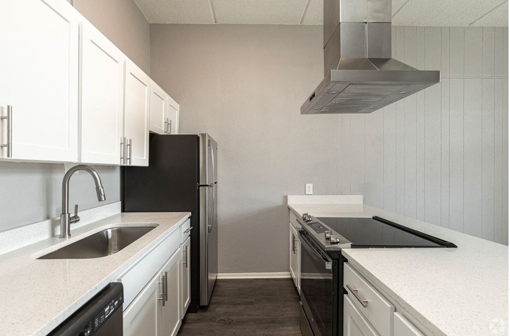 a kitchen with white cabinets and black appliances