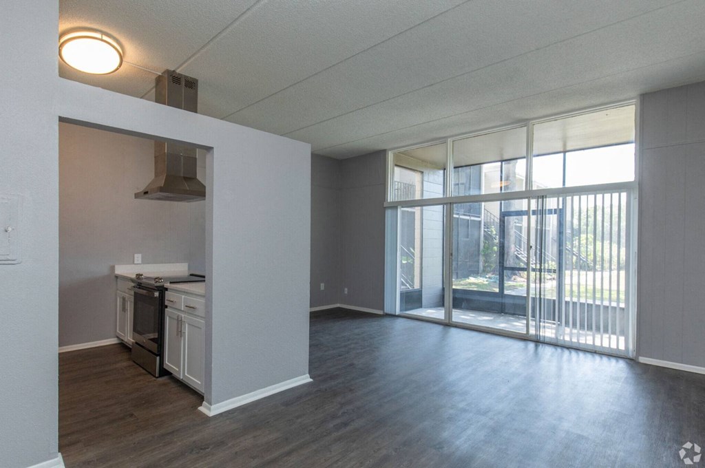 an empty living room with a stove and a balcony