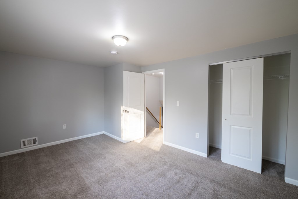 an empty living room with white doors and a carpet floor at Willowbrooke Apartments, Brockport, 14420