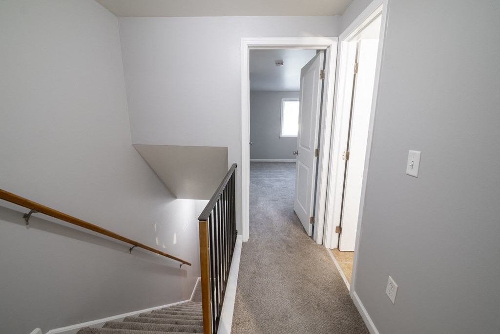 view from the top of the stairs looking down into the hallway and into the bedroom at Willowbrooke Apartments, New York