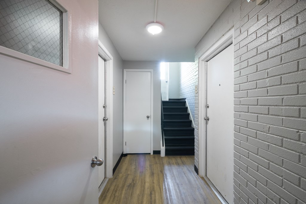 a hallway with white walls and a staircase with a white door at Willowbrooke Apartments, Brockport, NY