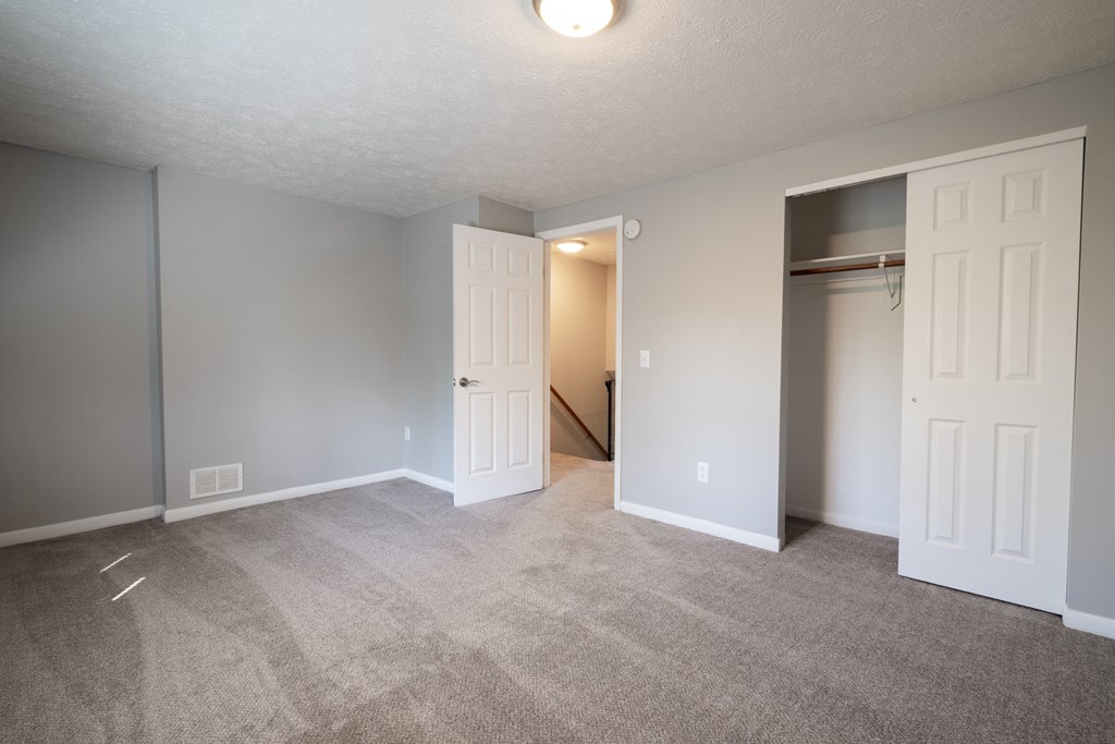 an empty living room with a door to a closet at Willowbrooke Apartments, Brockport