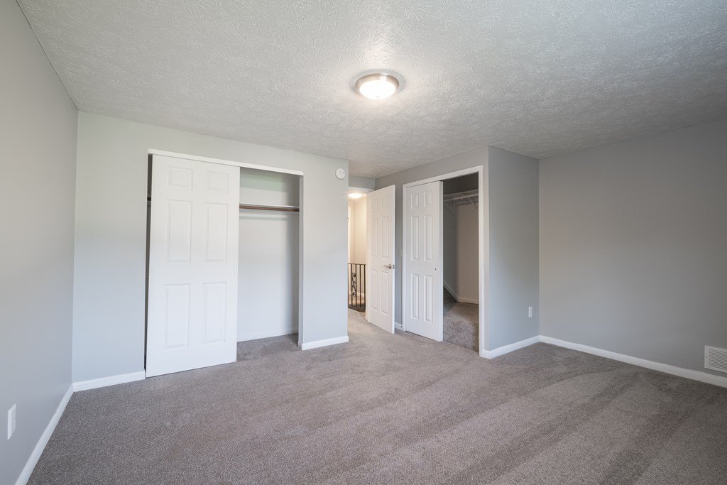an empty living room with white doors and a carpeted floor at Willowbrooke Apartments, Brockport, 14420