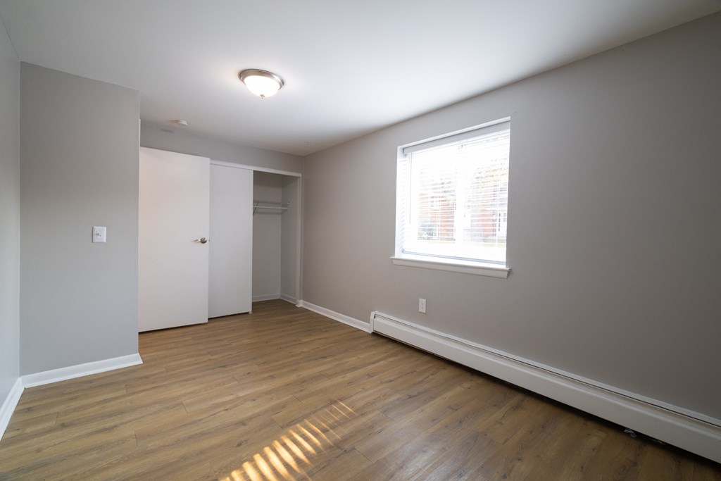 an empty living room with wooden floors and a window view at Willowbrooke Apartments, New York, 14420