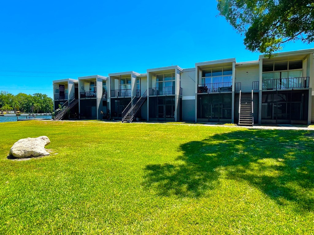 a row of apartments overlooking a grassy area and a body of water