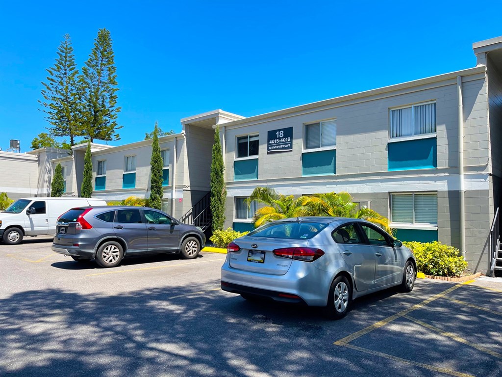 a large grey building with two cars parked in front of it