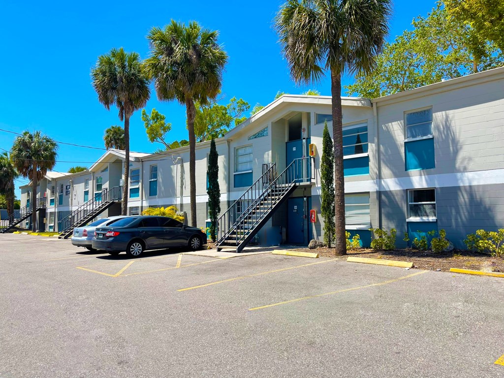 a row of apartment buildings with palm trees in front of them