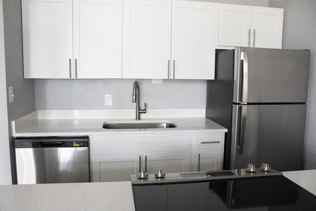 a kitchen with white cabinets and stainless steel appliances