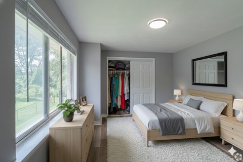 A bedroom with a large bed, a window with a view of a lawn, and a wooden dresser with a mirror above it.