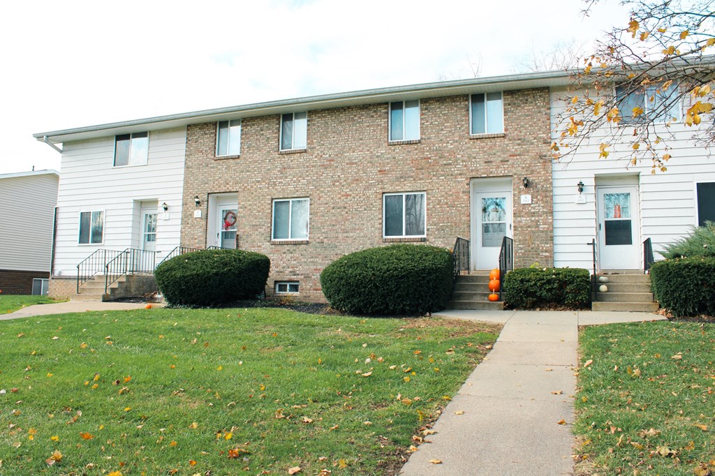 the front of a brick building with a sidewalk in front of it at Willowbrooke Apartments, Brockport, New York