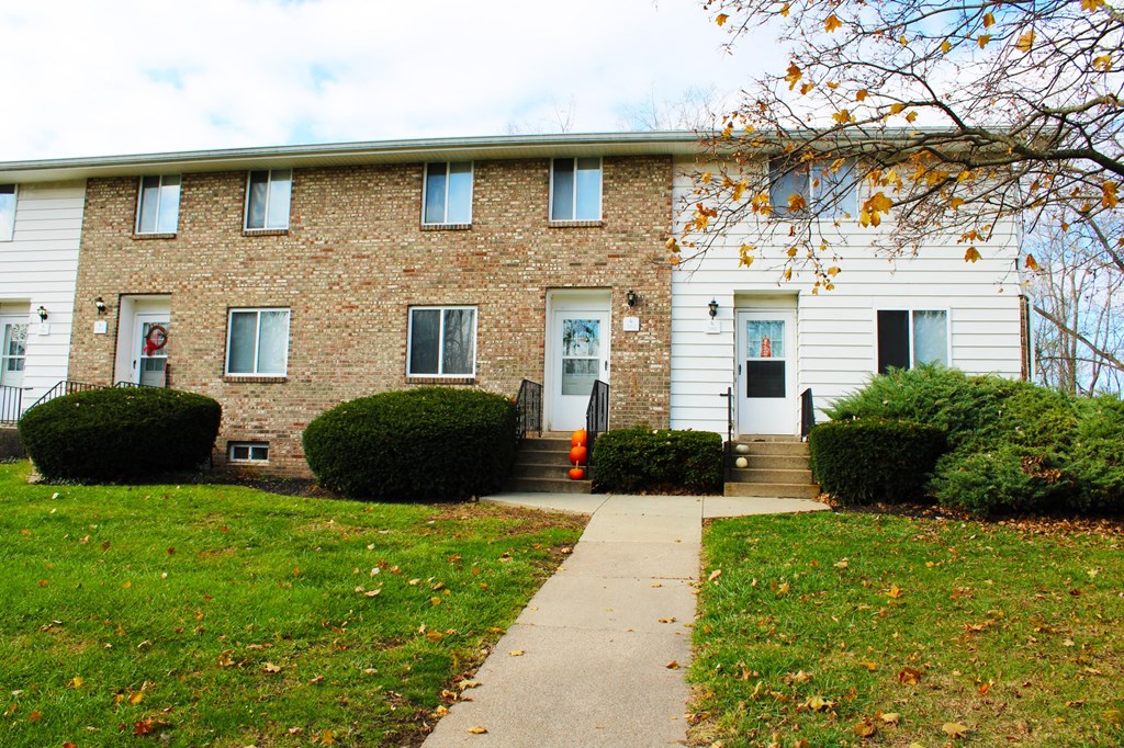 the front of a brick house with a sidewalk in front of it at Willowbrooke Apartments, Brockport
