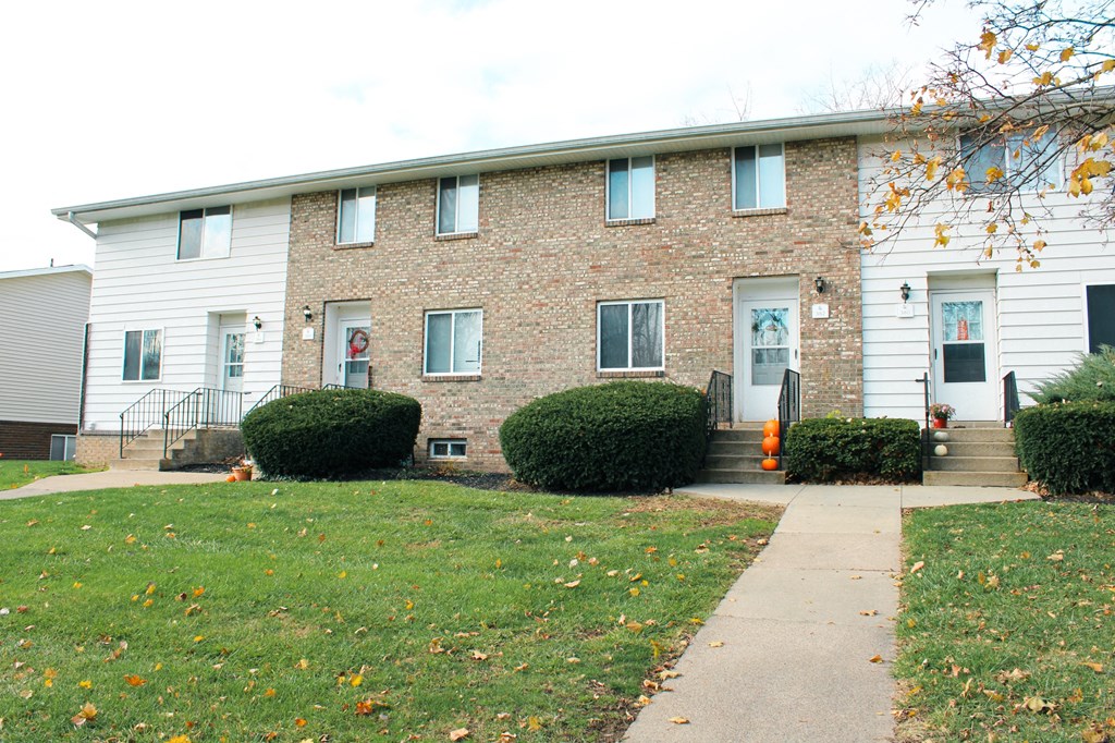 the front of a brick building with stairs and a sidewalk at Willowbrooke Apartments, Brockport, 14420