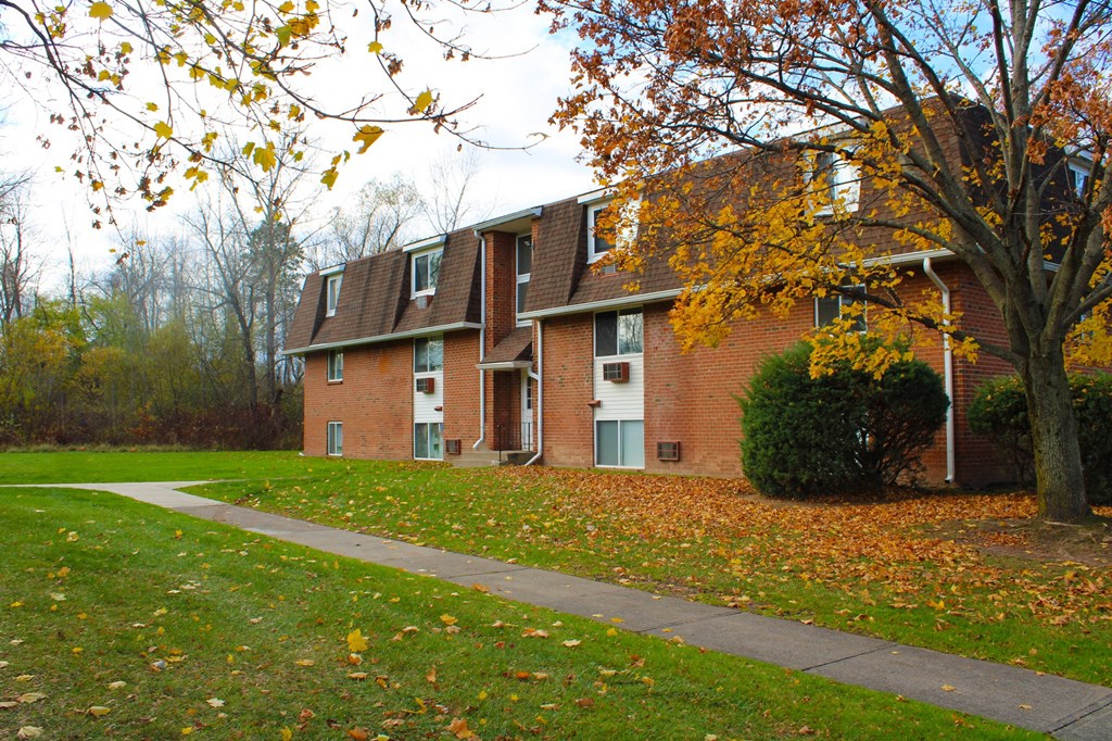 a red brick house with a sidewalk in front of it at Willowbrooke Apartments, New York