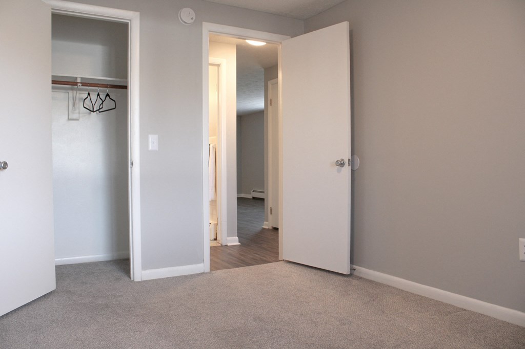a bedroom with a closet and an open door to a hallway at Willowbrooke Apartments, New York