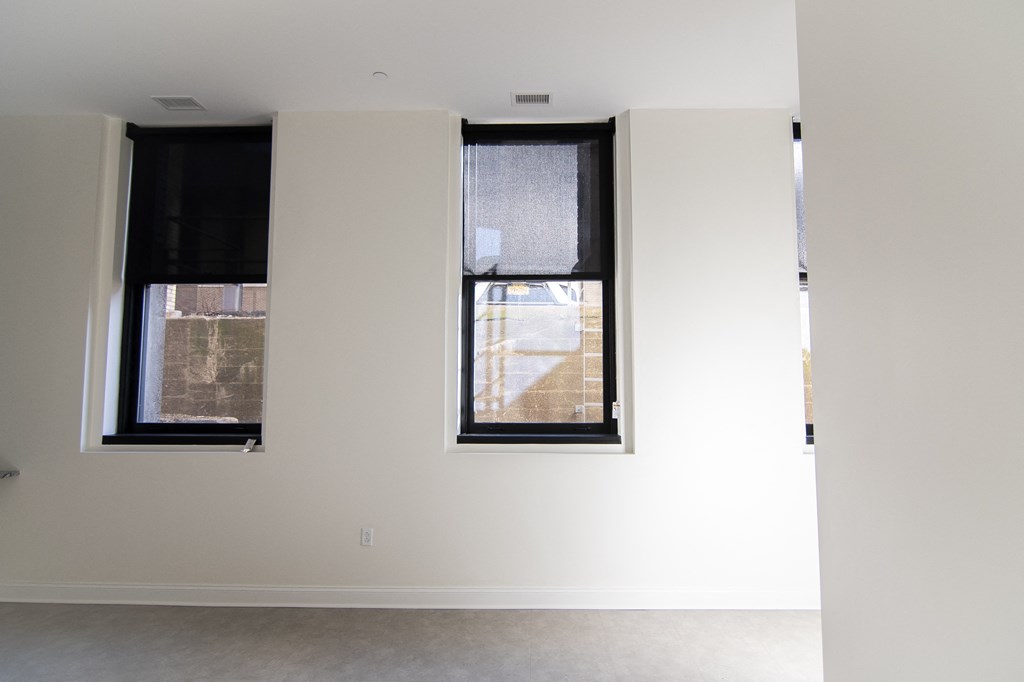 two windows in a room with white walls