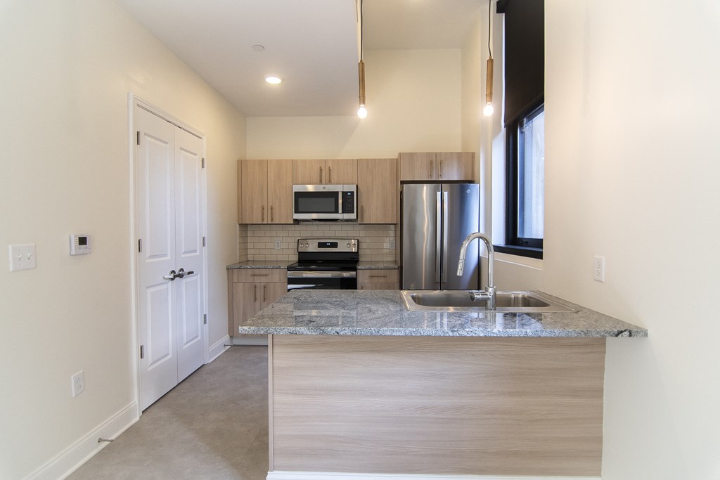 a kitchen with a granite counter top and a stainless steel refrigerator