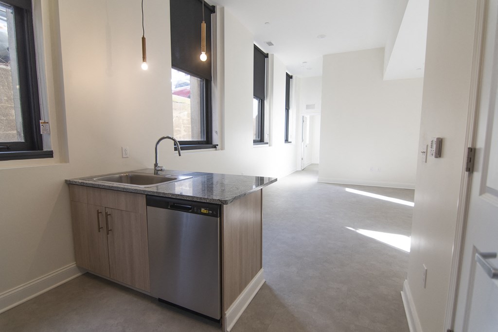 an empty kitchen with a sink and a counter top in a house