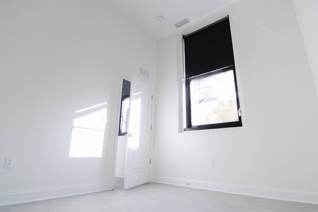 a large white room with a window and a door