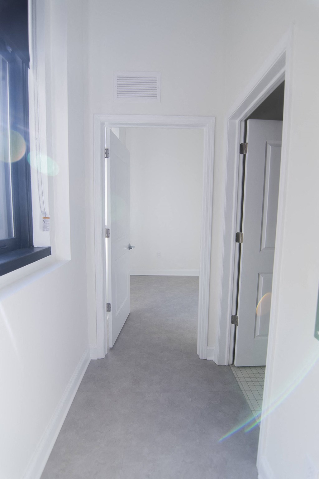 a white hallway with white walls and a white door