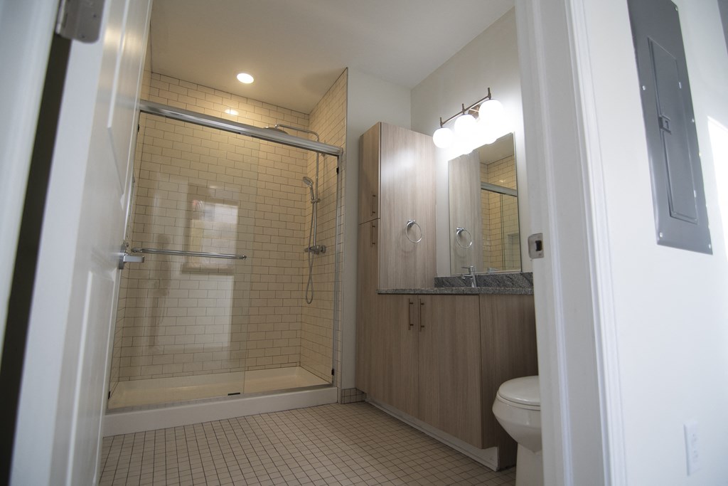 a bathroom with a shower and a sink and a toilet