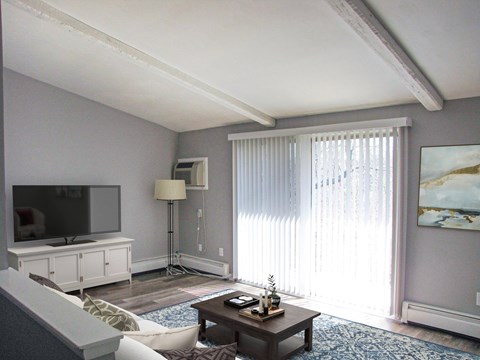 A living room with a television, a couch, a coffee table, and a painting on the wall.