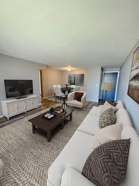 A living room with a white couch and a brown coffee table.