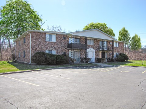 A large brick building with a parking lot in front.