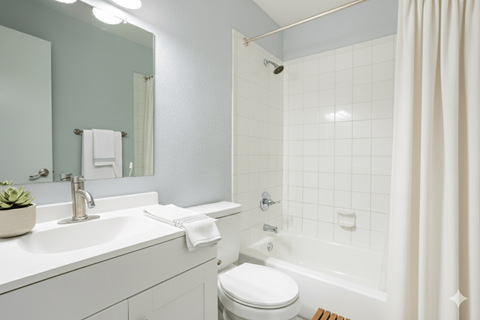 A white bathroom with a toilet, sink, and shower.