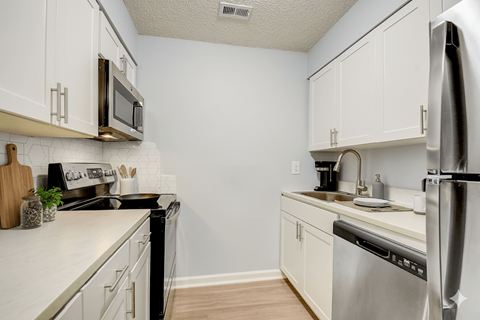 A kitchen with white cabinets and stainless steel appliances.