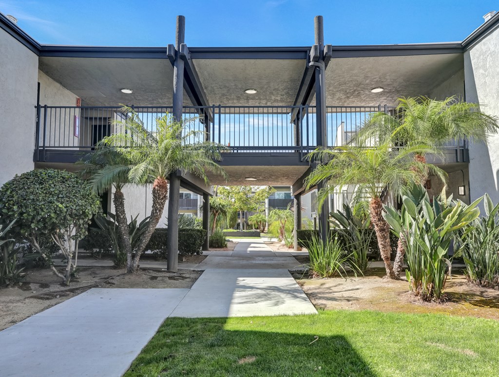 A modern building with a balcony and a walkway leading to it.