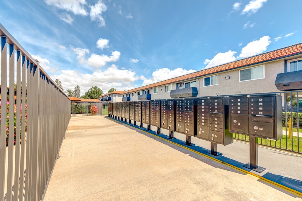 a row of metal mailboxes enclosed in a gated area