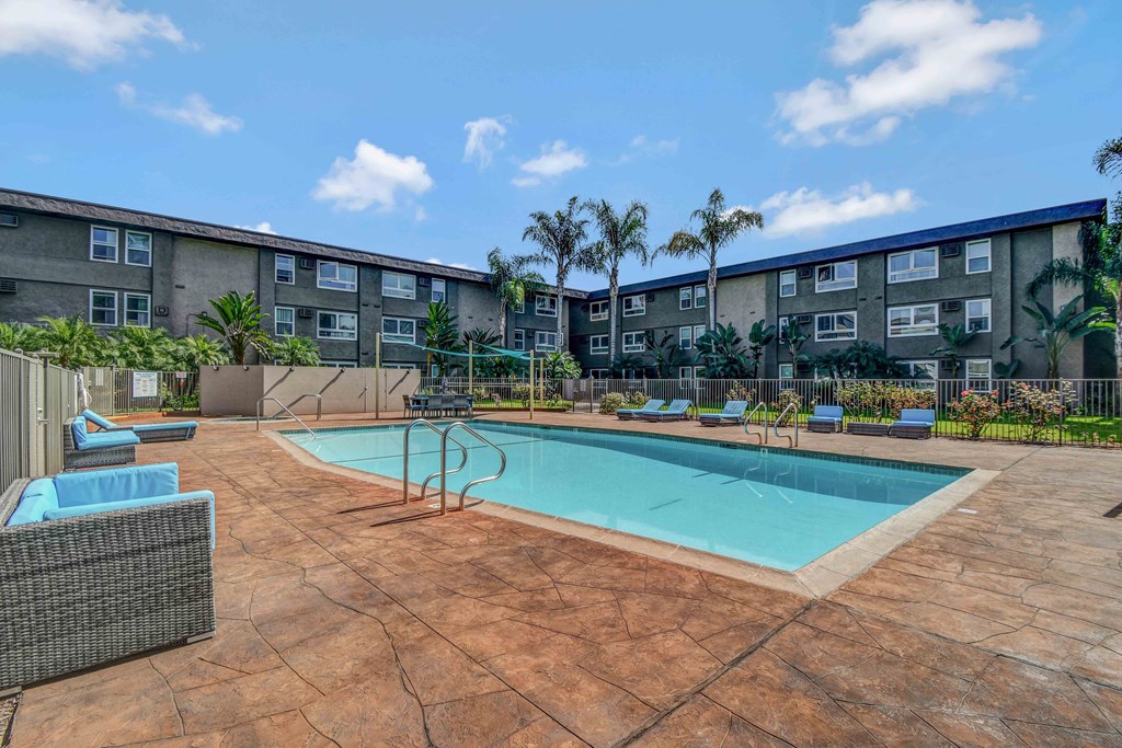 a swimming pool with an apartment building in the background